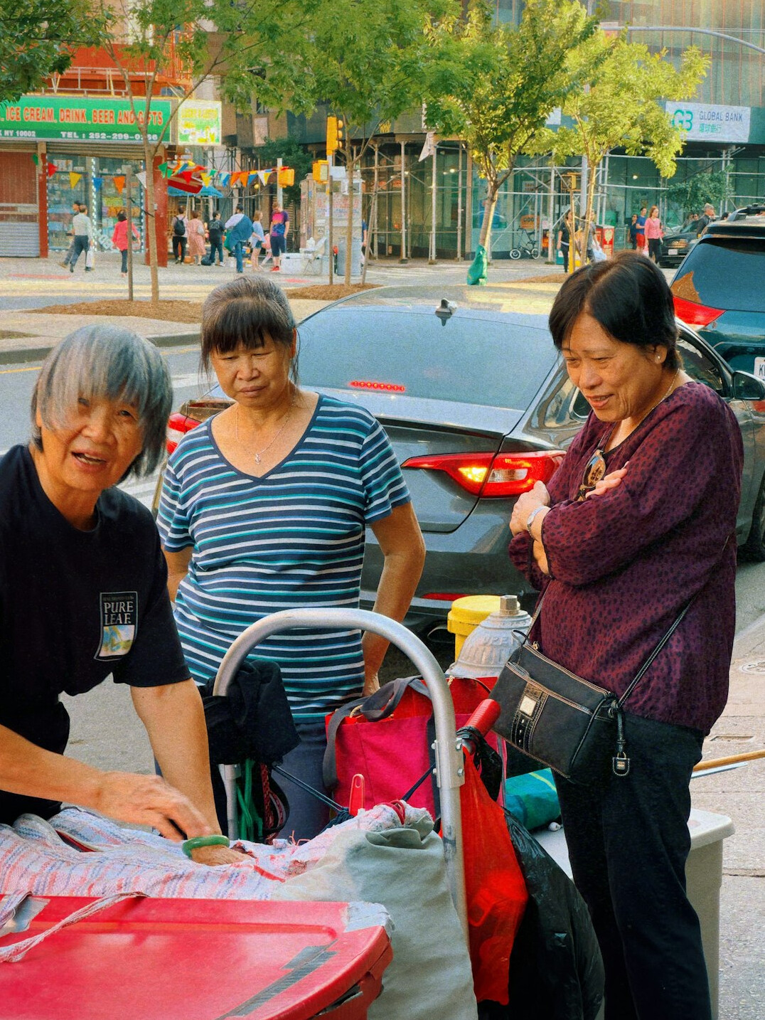 A younger volunteer helping an elderly woman carry groceries